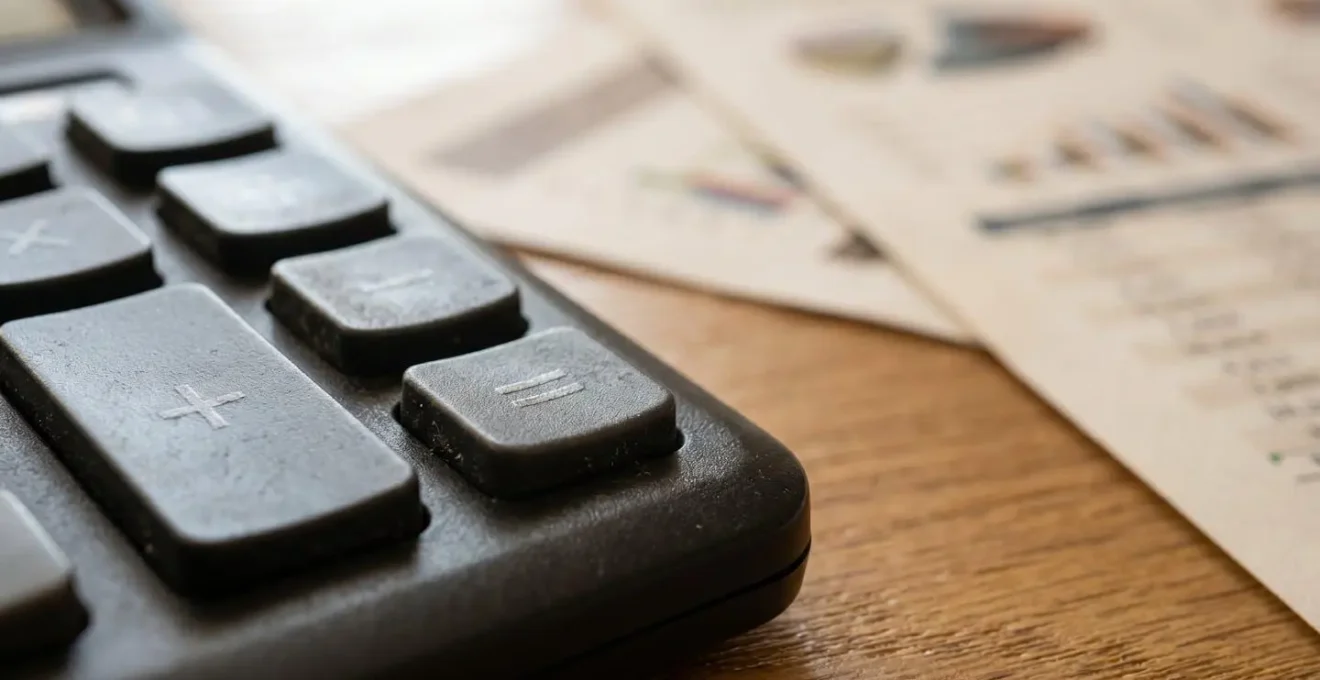 Vue macro de documents financiers avec calculatrice sur bureau en bois